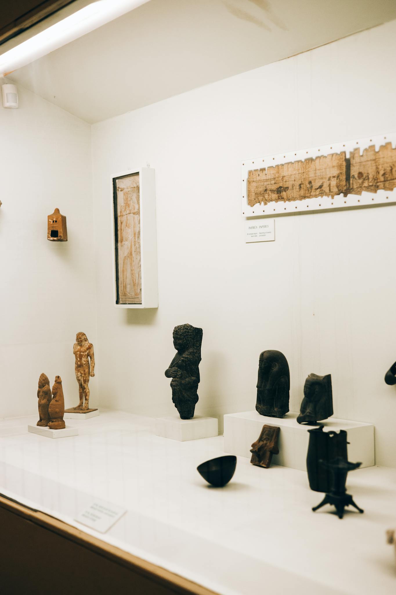A collection of ancient figurines and artifacts on display in a museum exhibit.