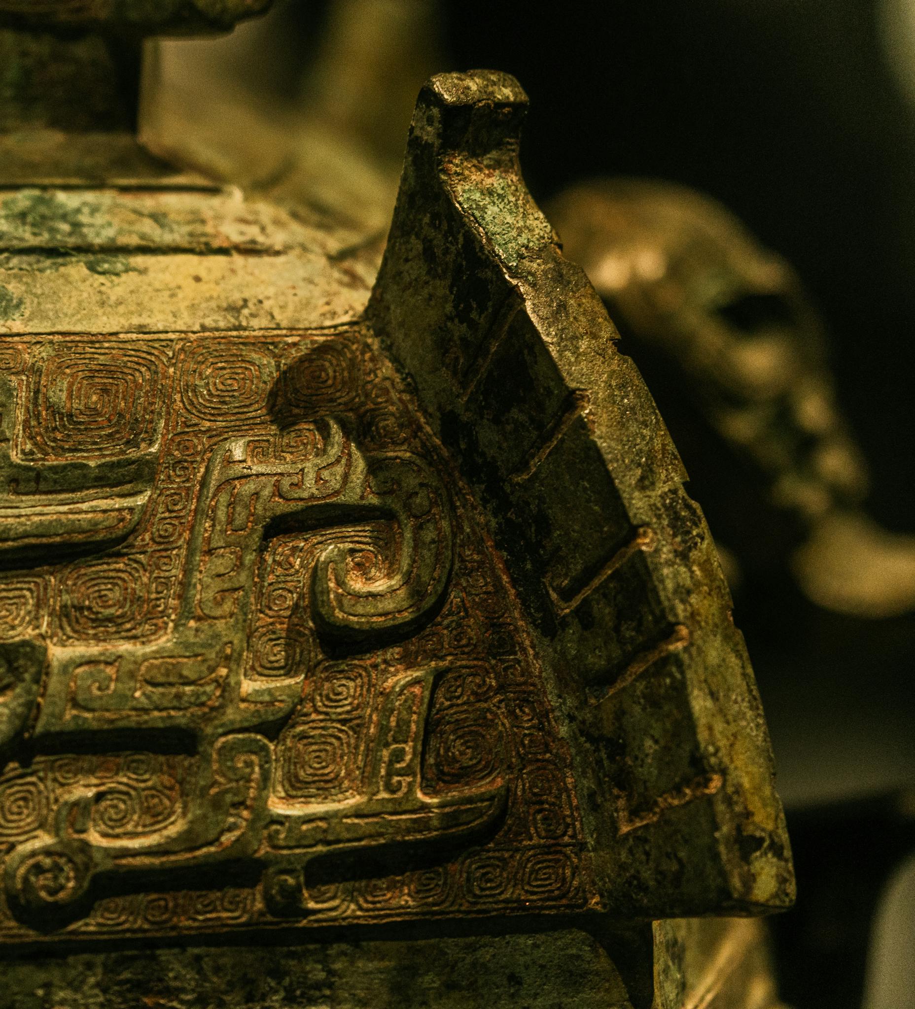 Detailed view of an ancient bronze artifact displaying intricate patterns and a weathered patina.
