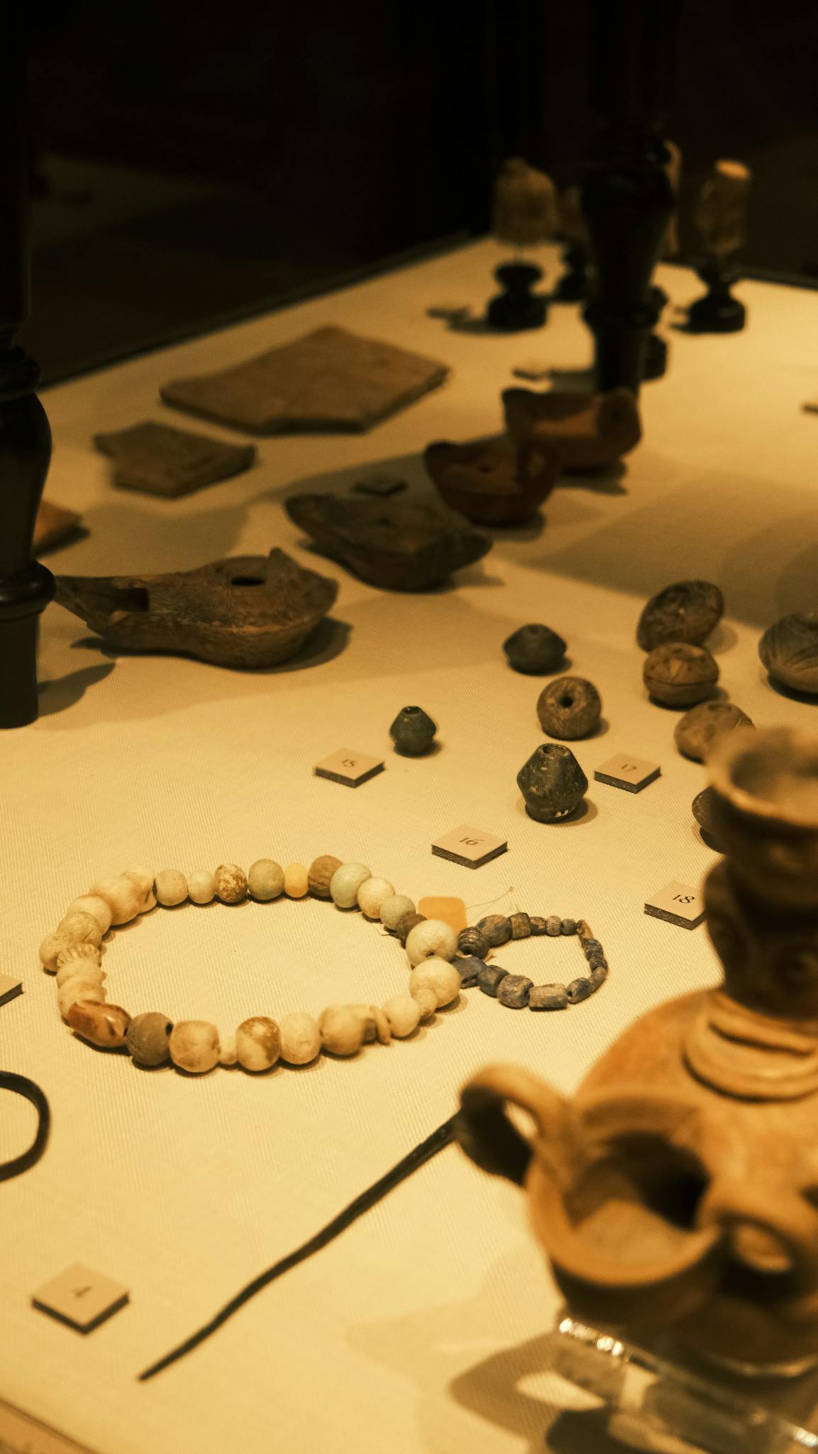 Exhibit of ancient artifacts including pottery and jewelry in a museum.
