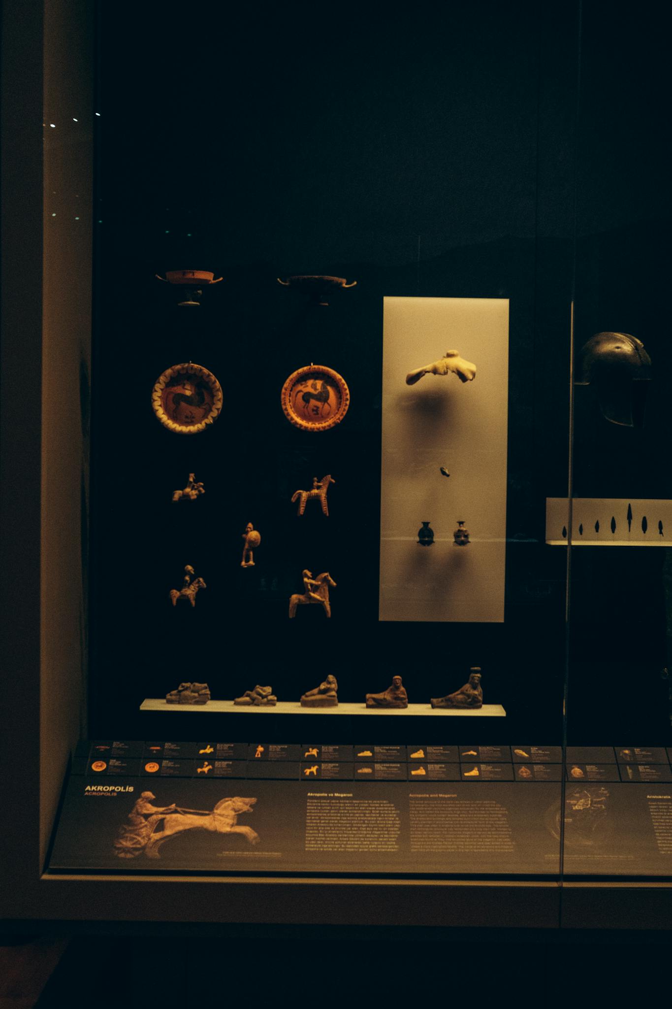 Exhibition of ancient figurines and artifacts in a museum display case in Turkey.